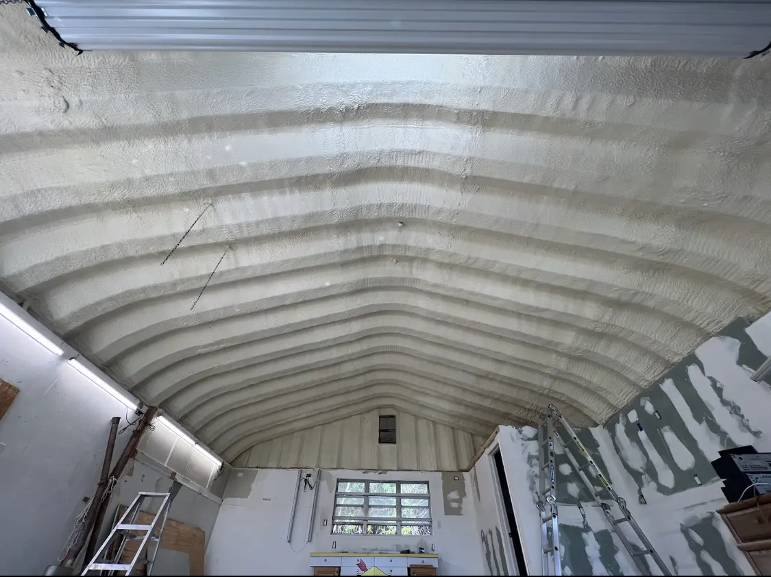 Spray polyurethane foam applied to the underside of a metal roof deck in Greene